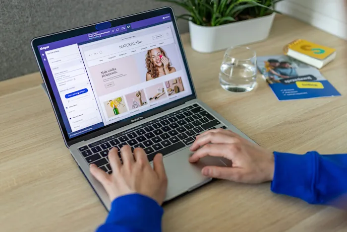 Two hands are typing in a laptop with the screen that shows an ecommerce website Brisbane. Photo from Unsplash.